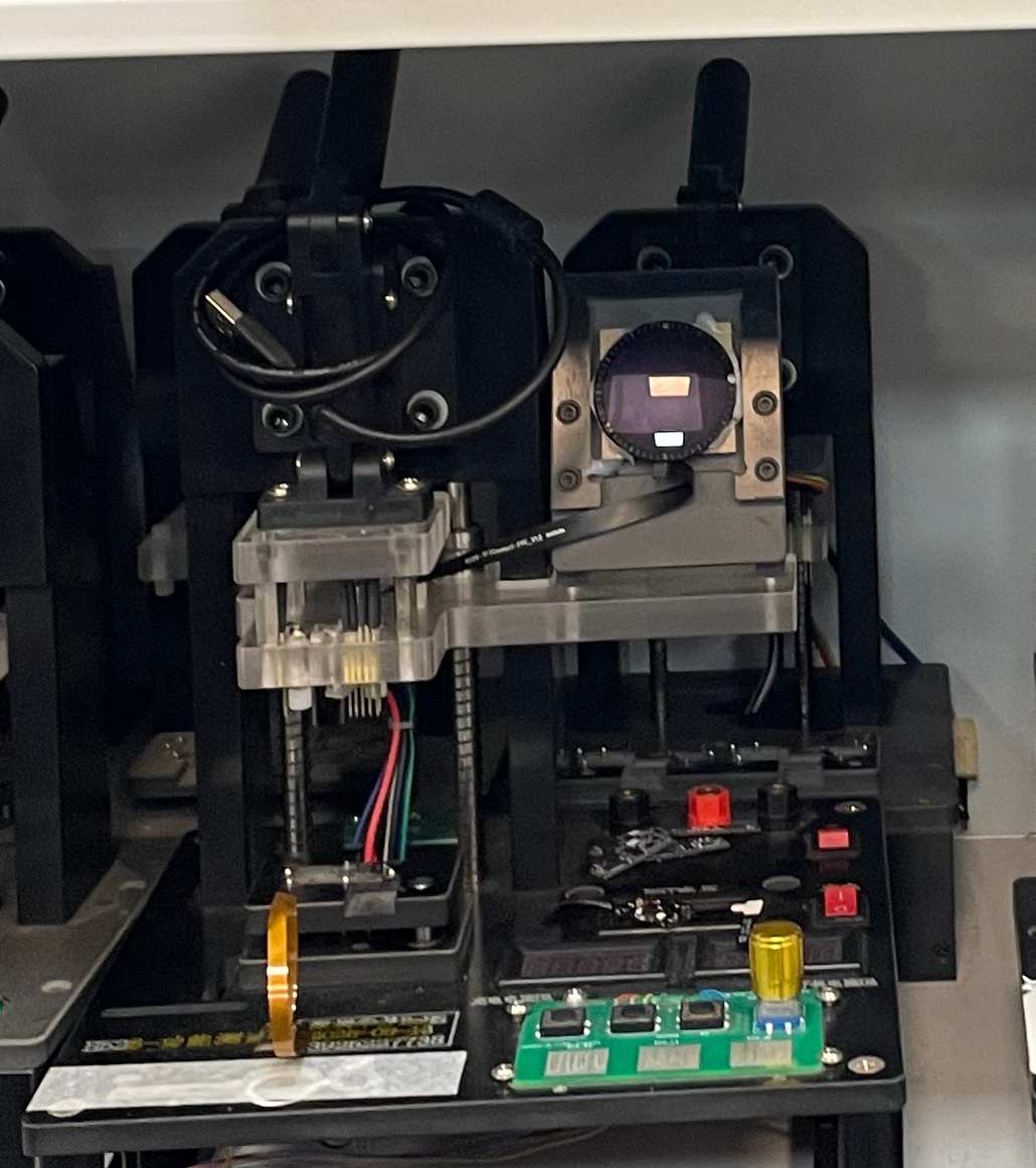 PCBA 测试设备细节，展示接触针、固定电路板、线缆与小型显示屏。